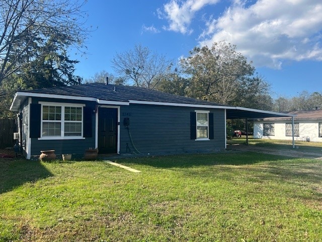 view of front of property with a front yard and a carport