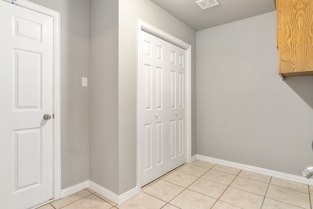 laundry area with light tile patterned flooring