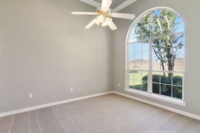 carpeted empty room with ceiling fan and crown molding