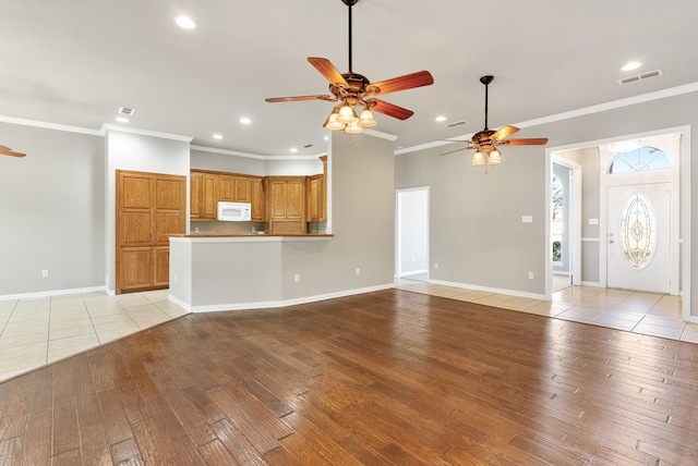 unfurnished living room featuring light hardwood / wood-style floors and crown molding