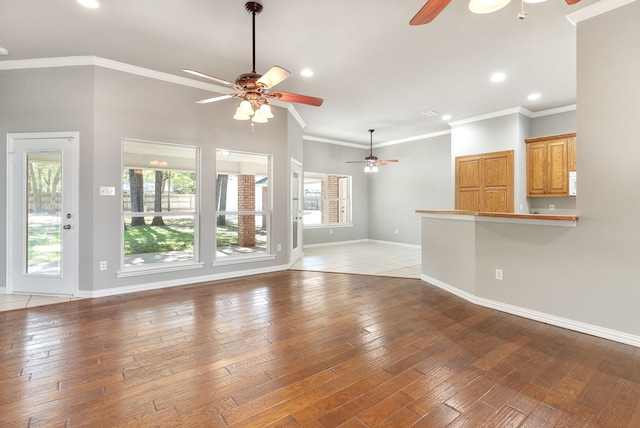 unfurnished living room featuring crown molding, ceiling fan, and hardwood / wood-style flooring