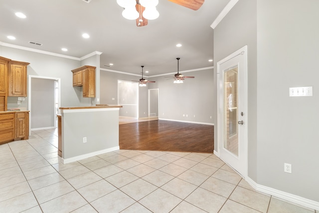 kitchen featuring ceiling fan, light tile patterned floors, and ornamental molding