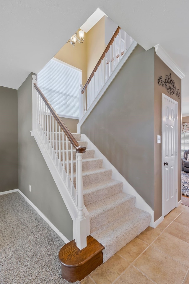 stairway featuring a chandelier and tile patterned flooring