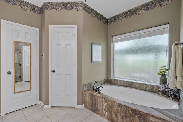 bathroom with tiled tub and tile patterned floors