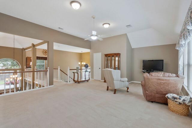 living area with light carpet, ceiling fan with notable chandelier, and vaulted ceiling