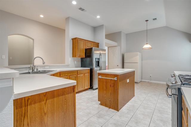 kitchen with appliances with stainless steel finishes, vaulted ceiling, sink, light tile patterned floors, and a center island