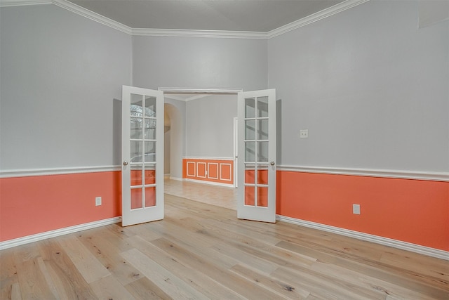 empty room with french doors, light hardwood / wood-style flooring, and crown molding