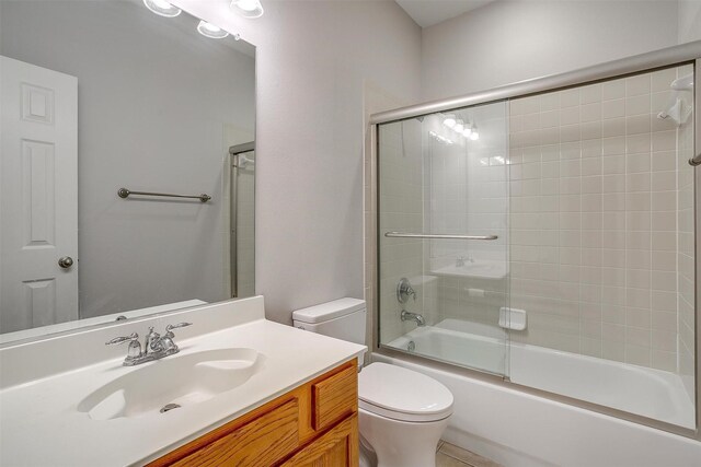 full bathroom featuring shower / bath combination with glass door, vanity, and toilet