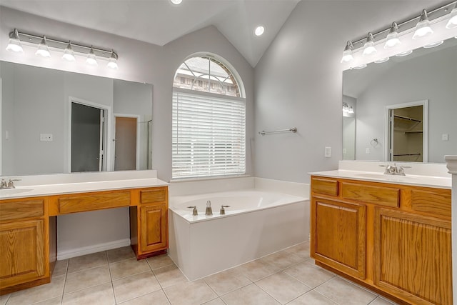 bathroom featuring vanity, vaulted ceiling, a bathtub, and tile patterned flooring