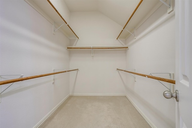 spacious closet featuring light carpet and vaulted ceiling