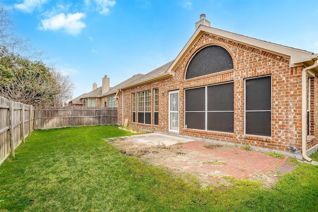 rear view of house featuring a patio area and a yard