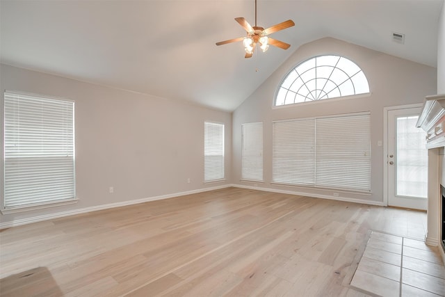 unfurnished room featuring light wood-type flooring, high vaulted ceiling, and ceiling fan