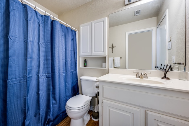 bathroom with vanity, a shower with shower curtain, a textured ceiling, and toilet