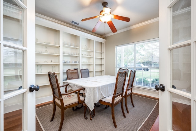 dining space with hardwood / wood-style floors, ceiling fan, crown molding, and french doors