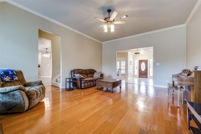 living room featuring hardwood / wood-style floors, ceiling fan, and crown molding