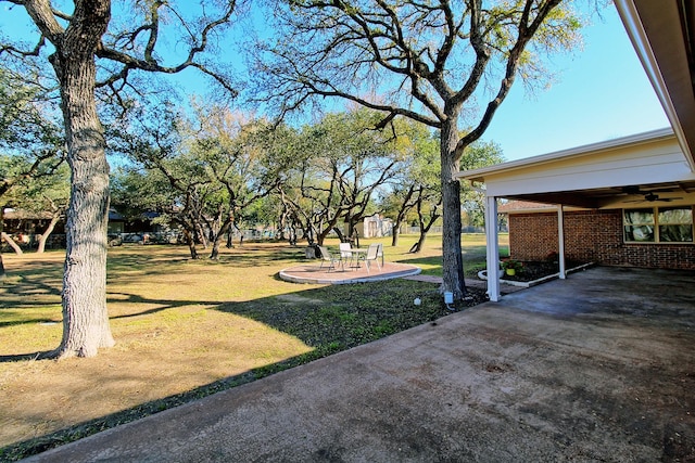 view of yard with ceiling fan and a patio area