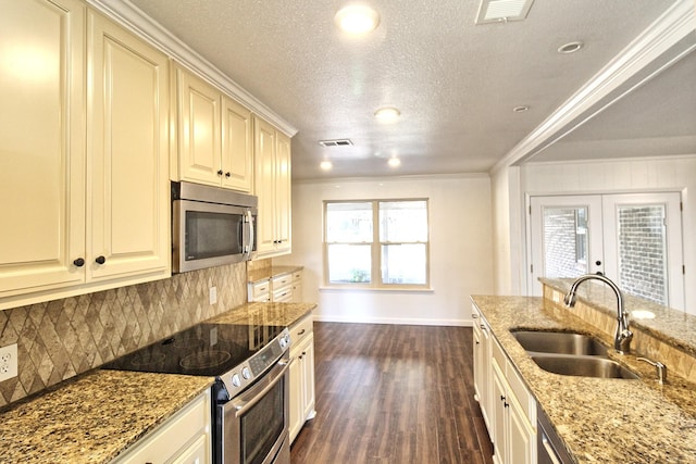 kitchen featuring light stone countertops, stainless steel appliances, crown molding, and sink