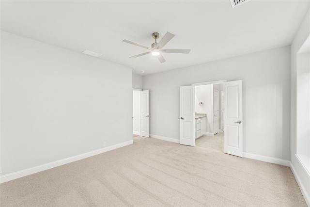 unfurnished bedroom featuring light colored carpet, ceiling fan, and ensuite bathroom