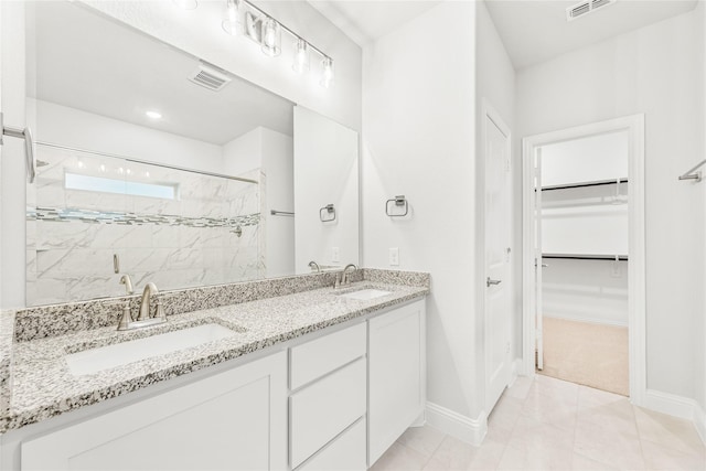 bathroom featuring vanity, a shower with shower door, and tile patterned floors