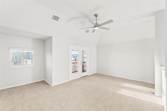 empty room featuring ceiling fan, vaulted ceiling, and light carpet