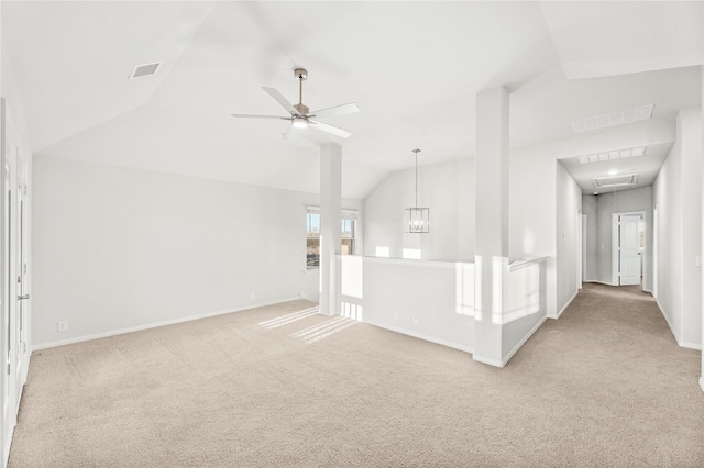 unfurnished living room with vaulted ceiling, ceiling fan with notable chandelier, and light carpet