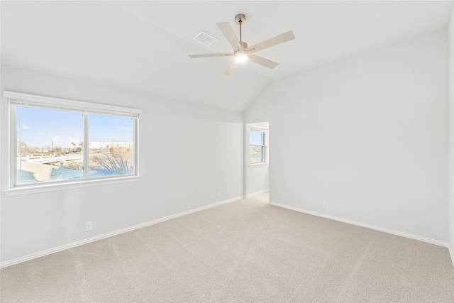 carpeted spare room with lofted ceiling, a wealth of natural light, and ceiling fan