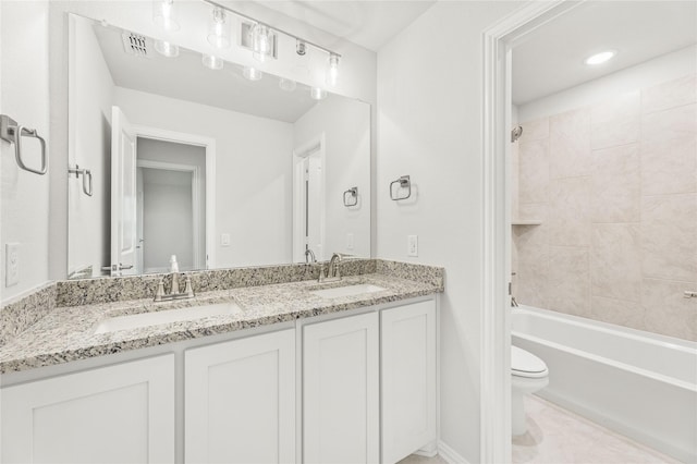 full bathroom with vanity, tiled shower / bath, and toilet