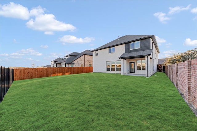 back of property with a yard and a patio