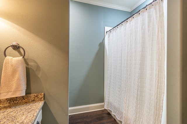 bathroom with hardwood / wood-style floors, vanity, and ornamental molding