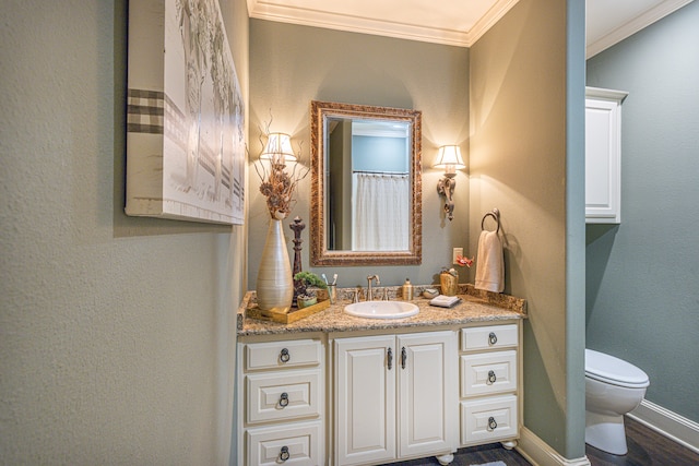 bathroom featuring crown molding, vanity, wood-type flooring, and toilet