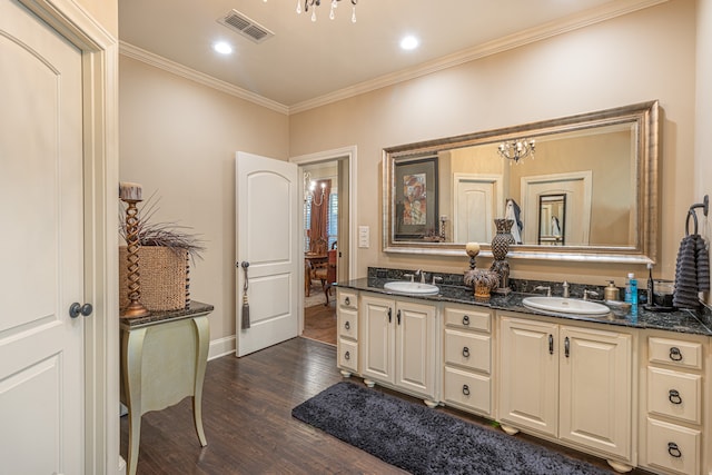 bathroom featuring wood-type flooring, vanity, crown molding, and a notable chandelier