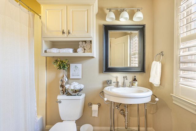 full bathroom with shower / bath combo with shower curtain, sink, and toilet