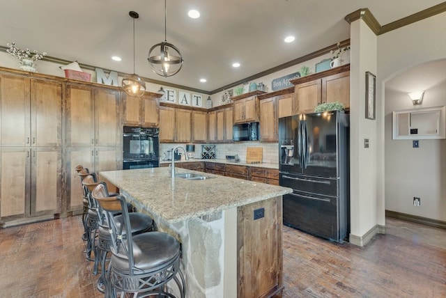 kitchen featuring arched walkways, black appliances, ornamental molding, and a sink