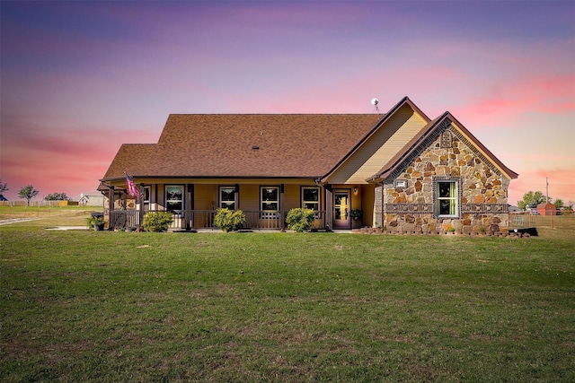 view of front of home with covered porch and a yard