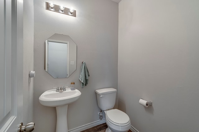 bathroom featuring toilet, sink, and hardwood / wood-style flooring