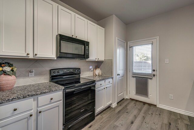 kitchen with light hardwood / wood-style flooring, white cabinetry, tasteful backsplash, black appliances, and stone counters