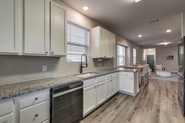 kitchen featuring kitchen peninsula, white cabinetry, dishwasher, and light wood-type flooring