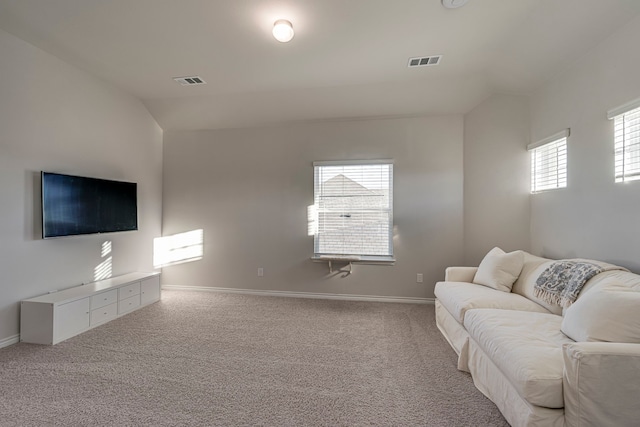 living room with light carpet, a healthy amount of sunlight, and vaulted ceiling