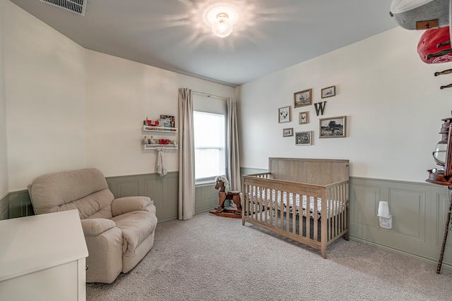 carpeted bedroom with a nursery area