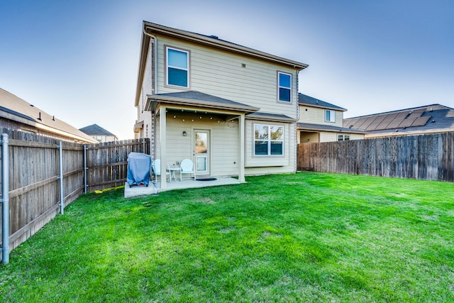 back of property with a lawn and a patio area