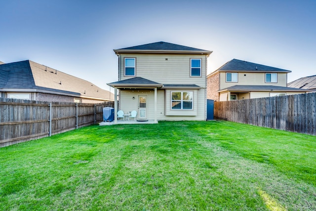 rear view of property with a yard and a patio