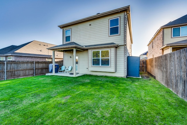 back of house with a patio area and a yard