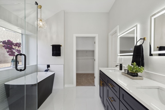 bathroom featuring vanity, an inviting chandelier, a tub, and a healthy amount of sunlight