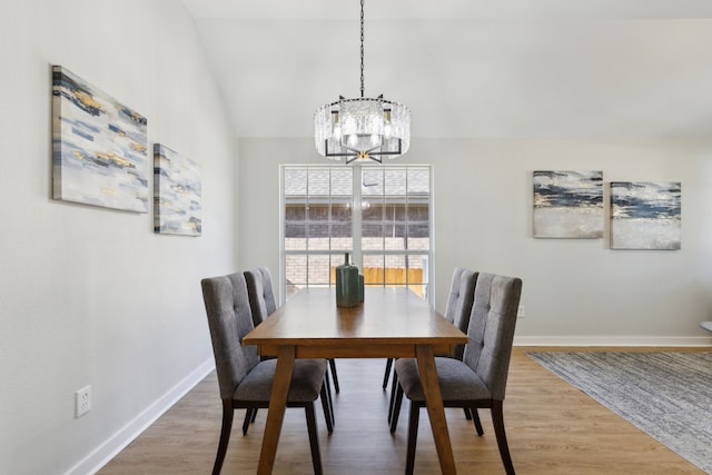 dining area with wood-type flooring and an inviting chandelier