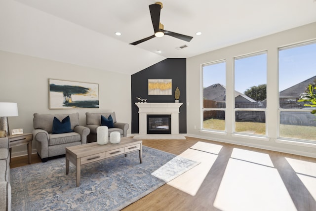 living room with ceiling fan, hardwood / wood-style floors, and lofted ceiling