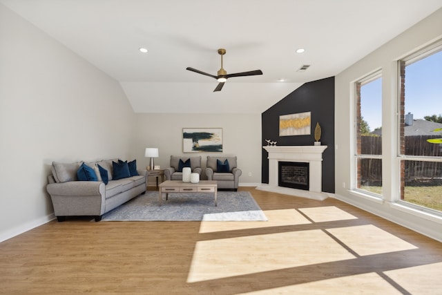 living room featuring vaulted ceiling, ceiling fan, and light wood-type flooring