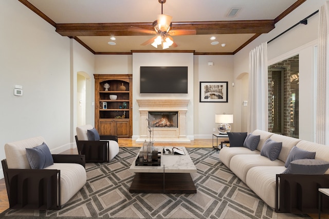 living room featuring beam ceiling, ceiling fan, hardwood / wood-style flooring, and ornamental molding