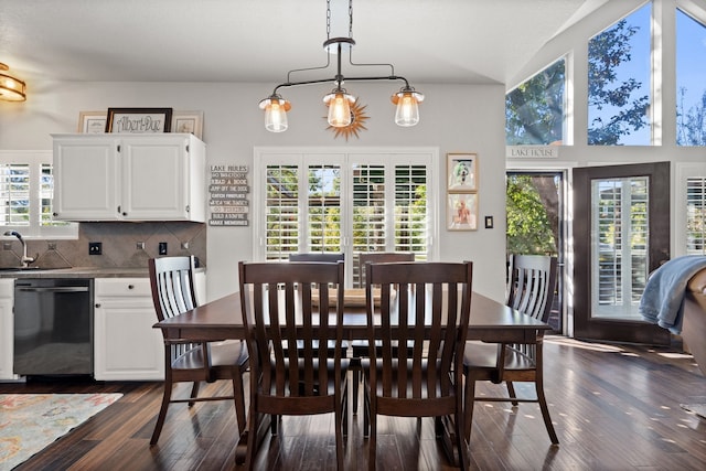 dining space with a chandelier, vaulted ceiling, dark wood-type flooring, and sink