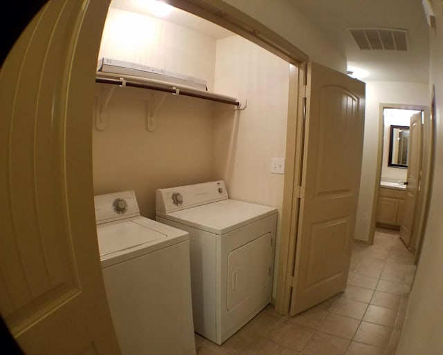 laundry room featuring washing machine and clothes dryer and light tile patterned flooring