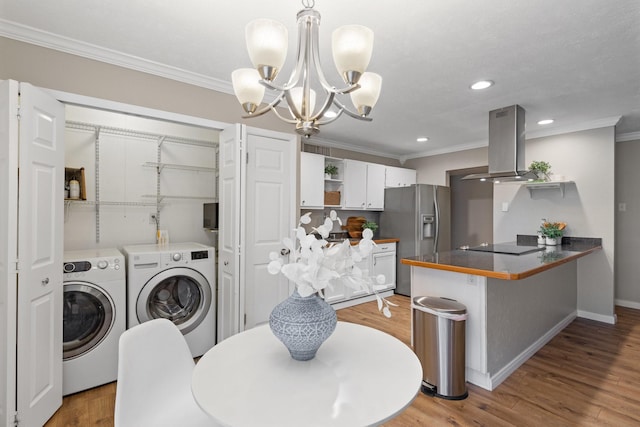 interior space featuring washer and clothes dryer, stainless steel fridge, island range hood, white cabinets, and kitchen peninsula